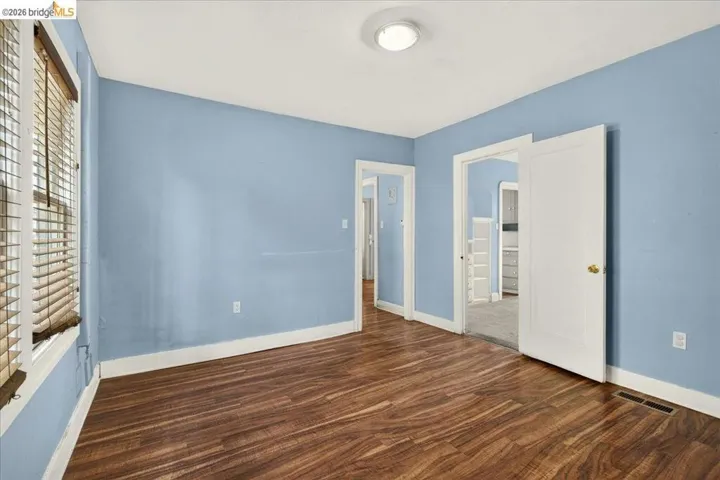 Room featuring wood-finish flooring, light blue walls, and a white ceiling