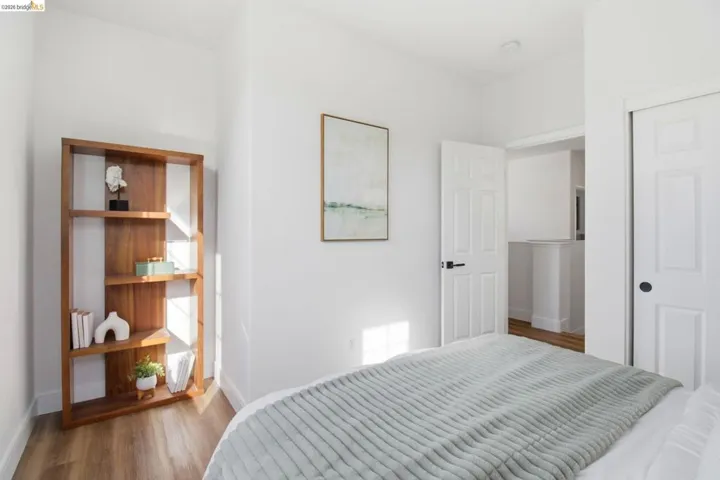 Room featuring light wood-finish flooring, white walls, and a built-in closet with sliding doors