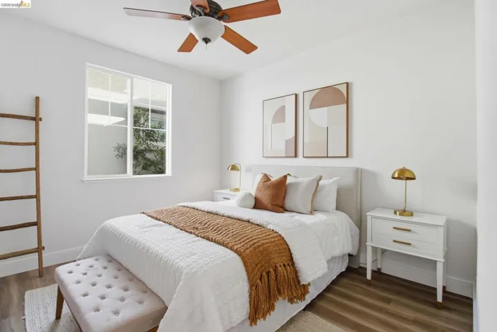 Bright bedroom featuring wood-finish flooring and a ceiling fan