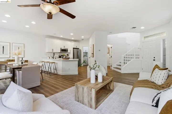 Open-concept living area with wood-finish flooring, recessed lighting, and a ceiling fan