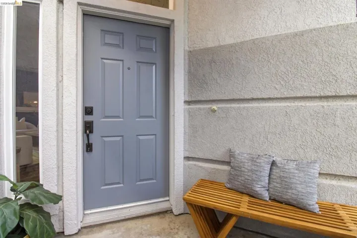 Entry door featuring a multi-panel design, dark hardware, and an adjacent sidelight
