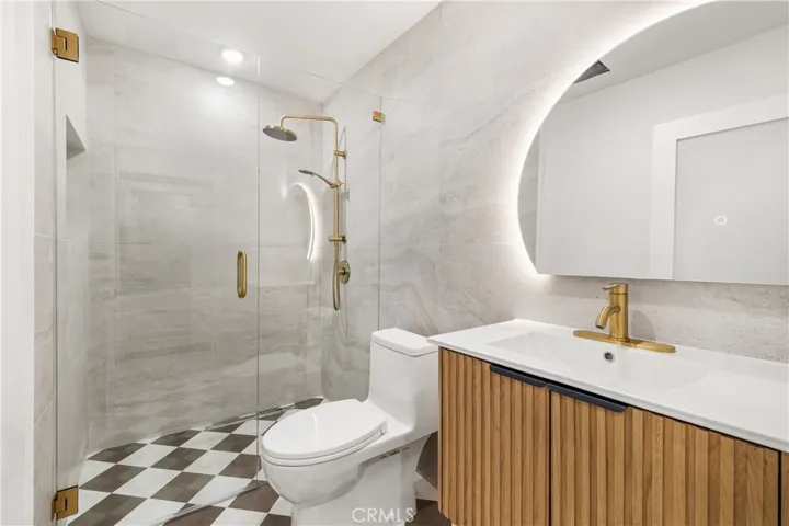 Spa-inspired bathroom with oversized tile, frameless glass shower, and designer fixtures.