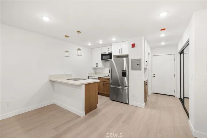 Designer kitchen featuring stone countertops, breakfast bar, and custom cabinetry.
