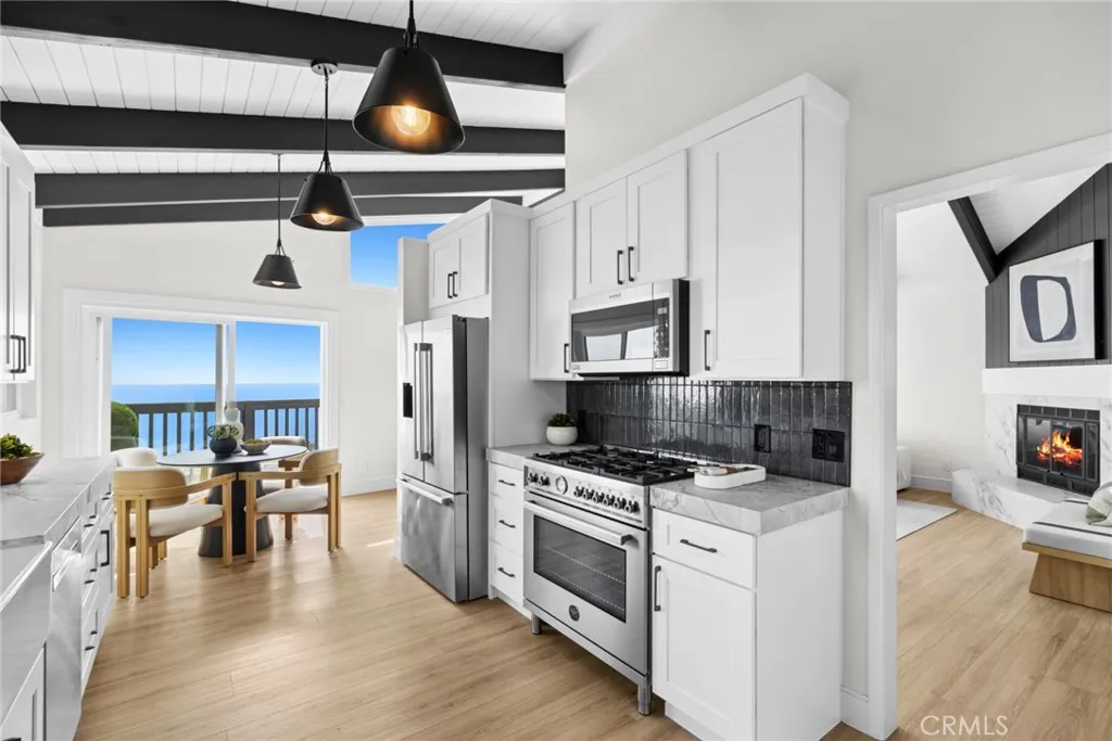The chef's kitchen flows seamlessly to a dining area made for entertaining against a backdrop of blue ocean, while a casual dining space in the kitchen invites everyday relaxation with ocean views.