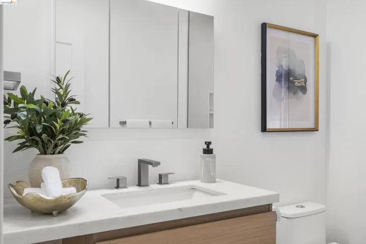 Bathroom vanity featuring a light-colored countertop, an undermount sink, and a matte gray three-piece faucet