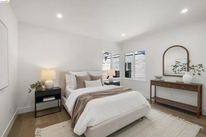 Bright bedroom featuring wood-finish flooring, recessed lighting, and white walls