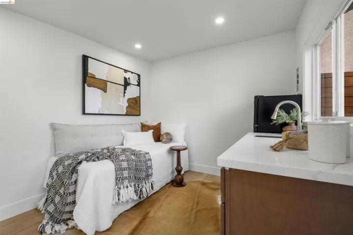 Built-in daybed with an upholstered headboard, recessed lighting, and wood-finish flooring