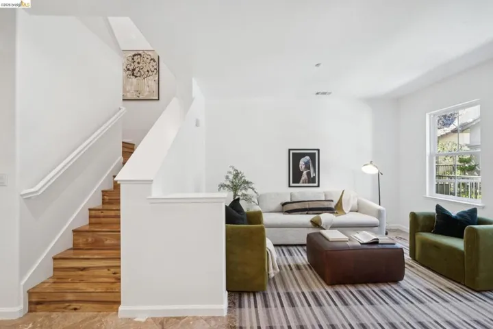 Inviting living area featuring a prominent staircase with wood-finish treads and a white railing