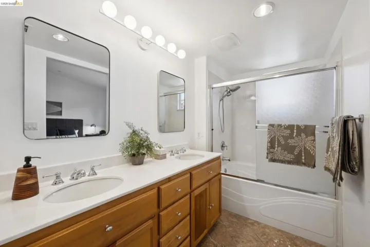 Double vanity with light wood-finish cabinetry and white countertops