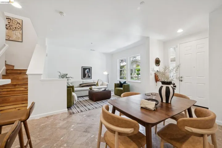 Open-concept living space featuring a paneled entry door with sidelight, three-pane windows, and recessed lighting