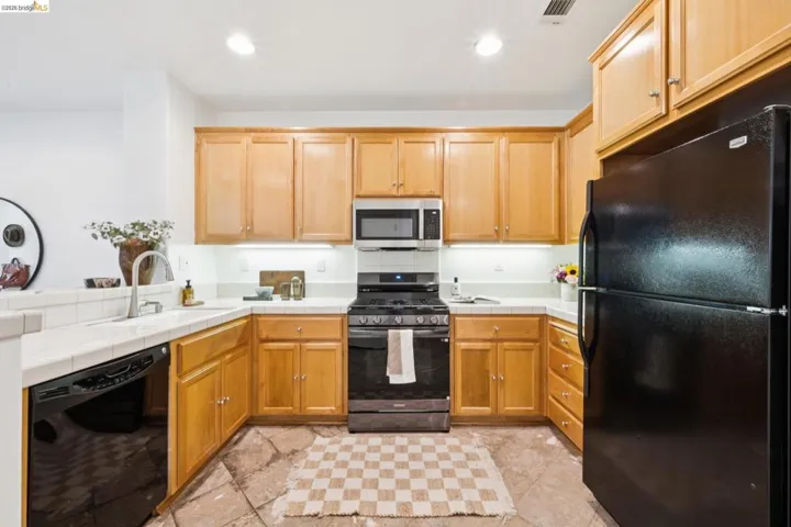 U-shaped kitchen featuring wood cabinetry and light-toned countertops