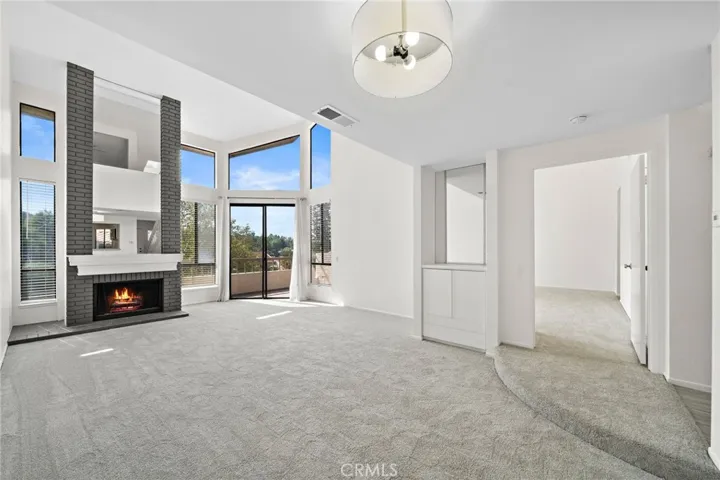 Welcoming living room, where a striking floor-to-ceiling fireplace with dark charcoal brick and a white mantel acts as a bold architectural centerpiece.