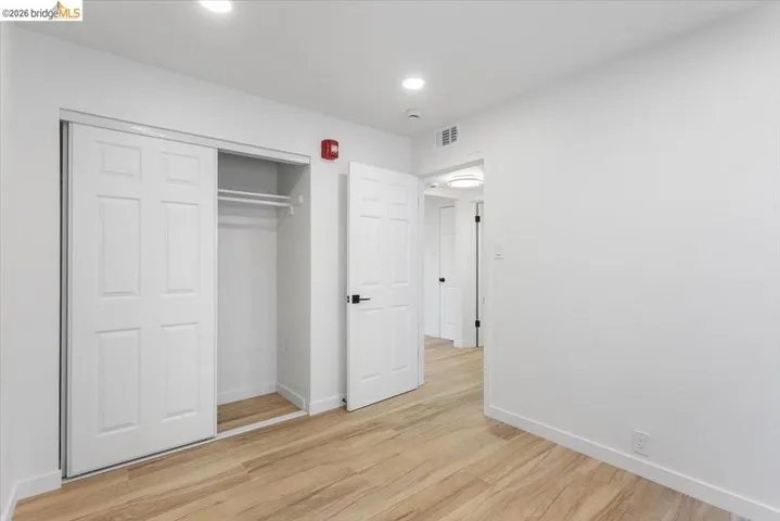 Unfurnished bedroom with light wood-type flooring, a closet, and recessed lighting