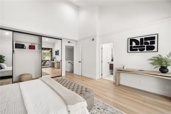 Spacious primary suite with private balcony and mirrored closets
