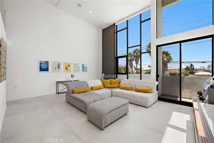 Soaring double-height ceilings and dramatic floor-to-ceiling windows flood a loft-like open-concept living.