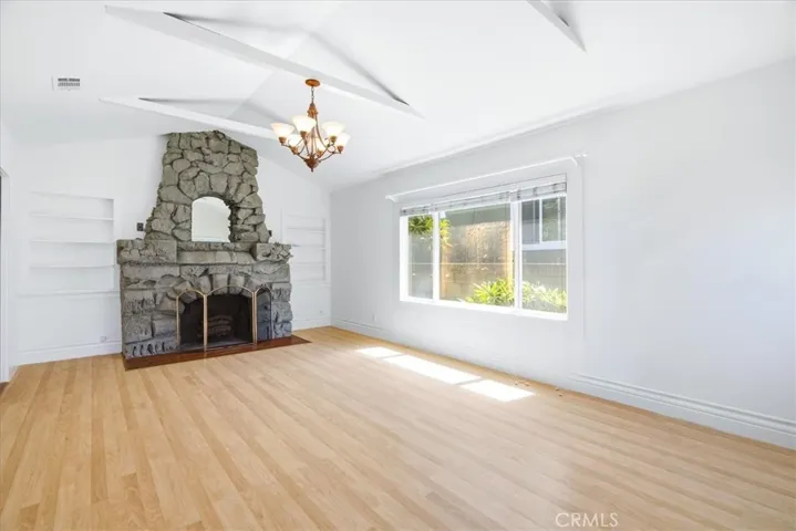 Living room view featuring the stone fireplace, open floor plan, and spacious area for relaxation and gatherings.