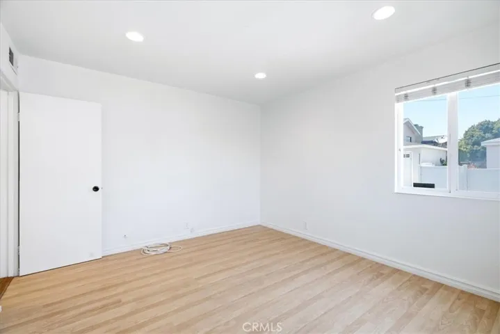 Additional room perspective highlighting the bright space, wood flooring, and welcoming interior.