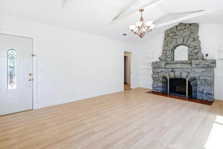 Alternate living room angle showcasing the fireplace centerpiece, clean design, and inviting open space.