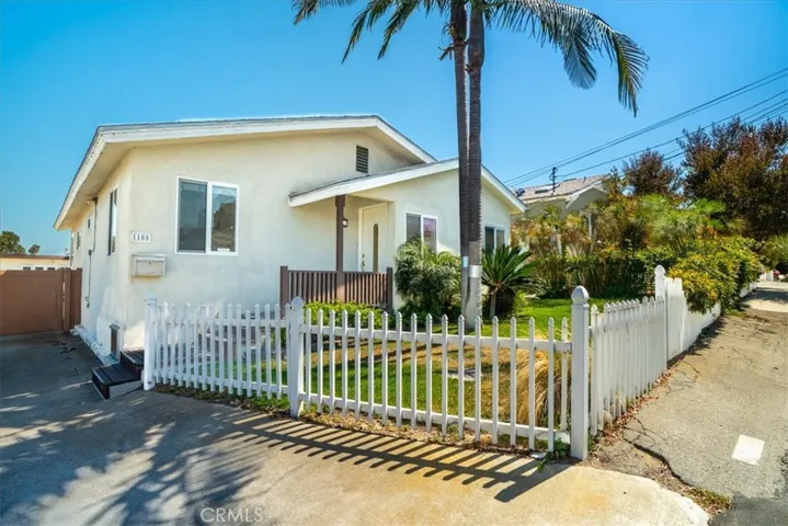 Exterior angle highlighting the front entry, gated walkway, and well-maintained landscaping.