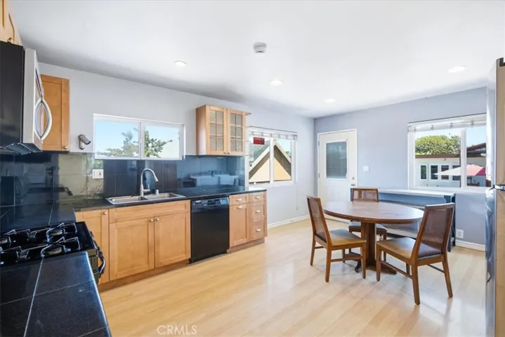 Open kitchen and dining area highlighting the seamless flow between spaces, natural light, and inviting atmosphere.