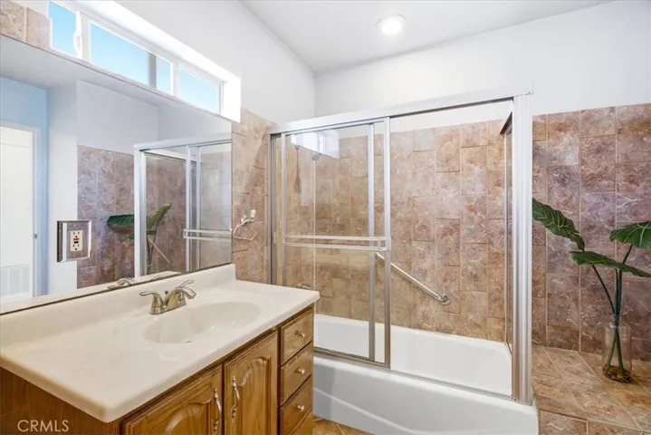 Additional bathroom perspective highlighting the countertop, cabinetry, and shower area finishes.