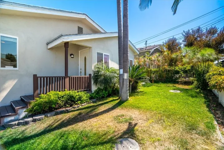 Front exterior view showcasing the landscaped yard, mature greenery, and charming curb appeal.