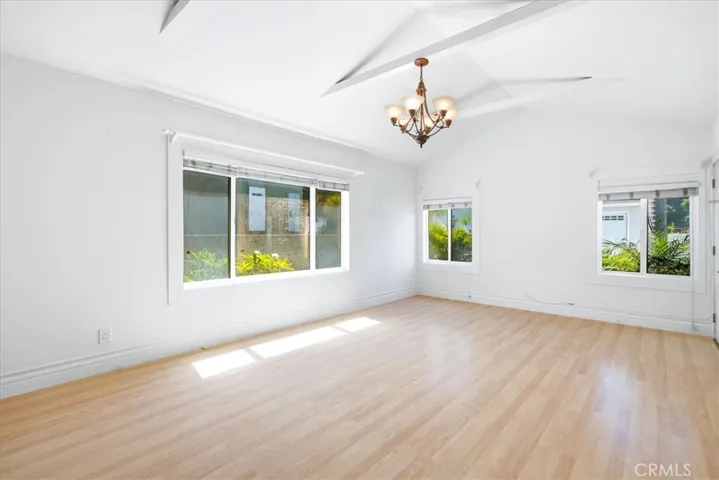 Additional view of the living area highlighting the large windows, wood flooring, and airy atmosphere.