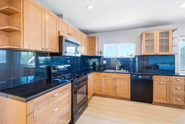 Kitchen view showcasing the warm cabinetry, sleek countertops, and functional layout designed for everyday cooking and entertaining.