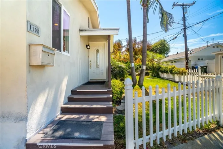 Entry pathway view highlighting the steps, gate detail, and approach to the home's entrance.