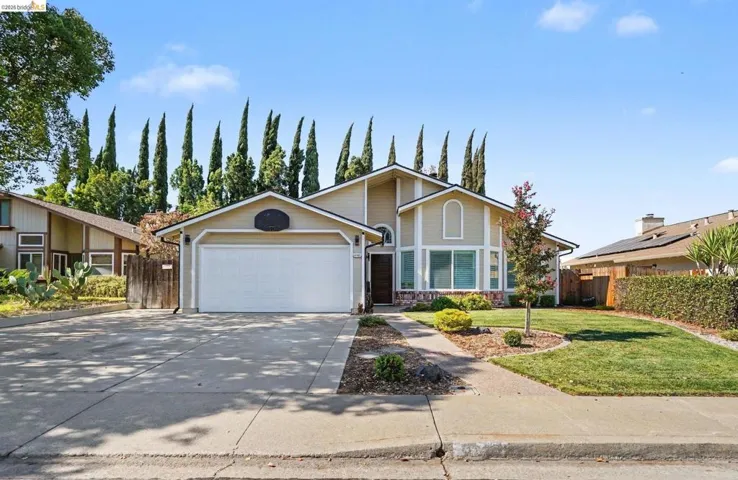 Two-story residence featuring a neutral-toned exterior, an attached two-car garage, and a concrete driveway