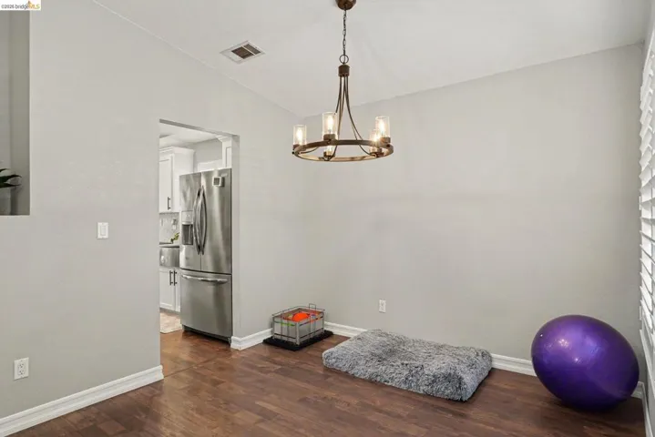 Dining area featuring a bronze-finish chandelier, wood-finish flooring, and light gray wall paint