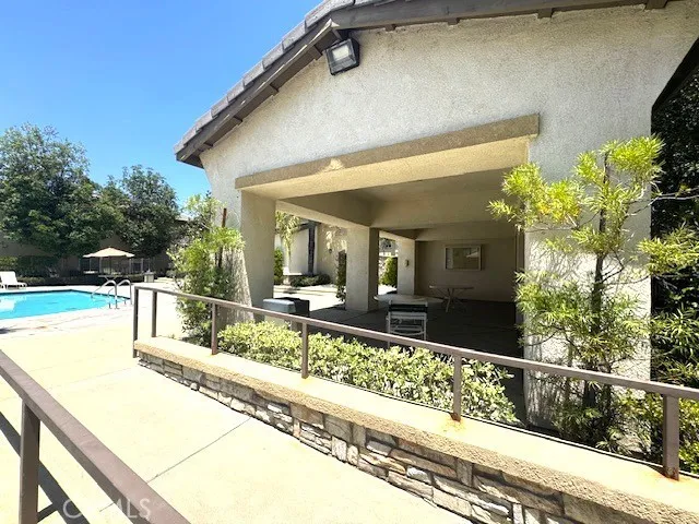 covered lounge area by the pool .