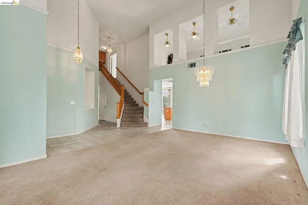 Open concept living area featuring high vaulted ceilings and a two-tone wall treatment