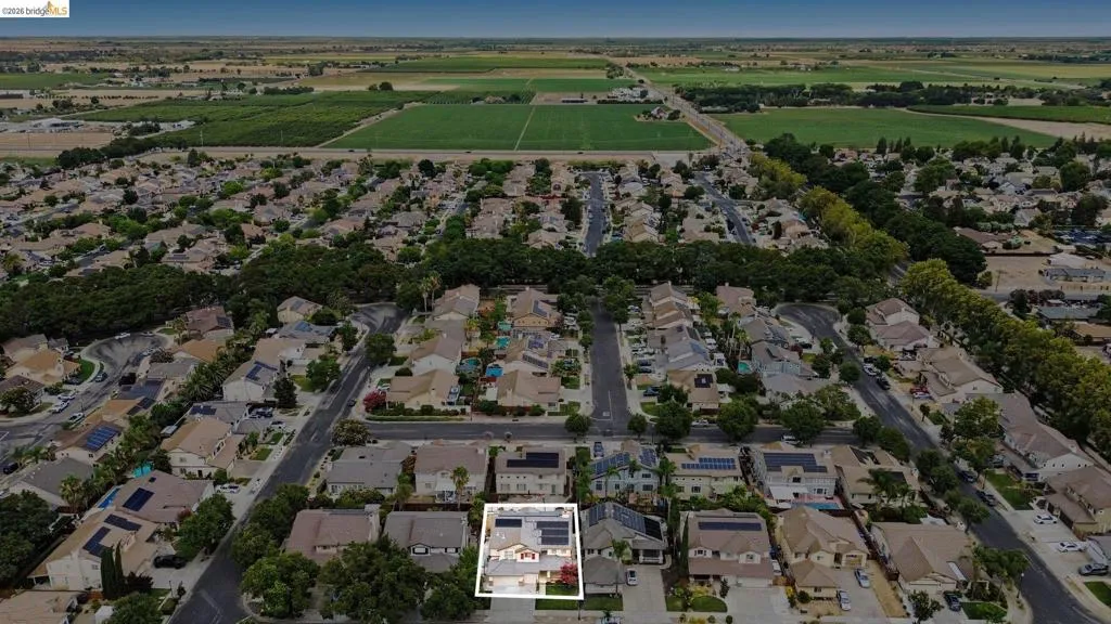 Aerial perspective showcasing a residential neighborhood surrounded by agricultural fields