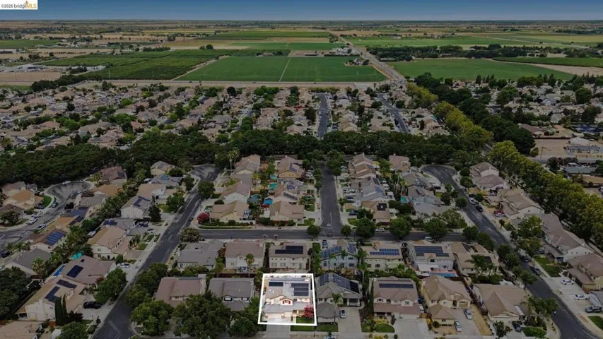 Aerial perspective showcasing a residential neighborhood surrounded by agricultural fields
