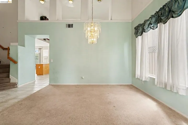 Spacious interior with vaulted ceilings and a tiered chandelier