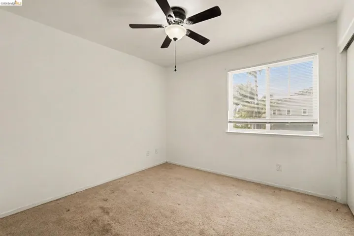 Room featuring a white ceiling and walls with carpeted flooring