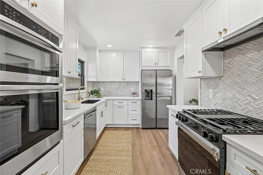 2 ovens & sleek Zephyr hood vent.