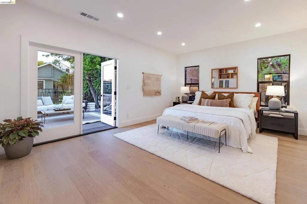 Light wood-finish flooring extending to glass French doors and a private outdoor patio