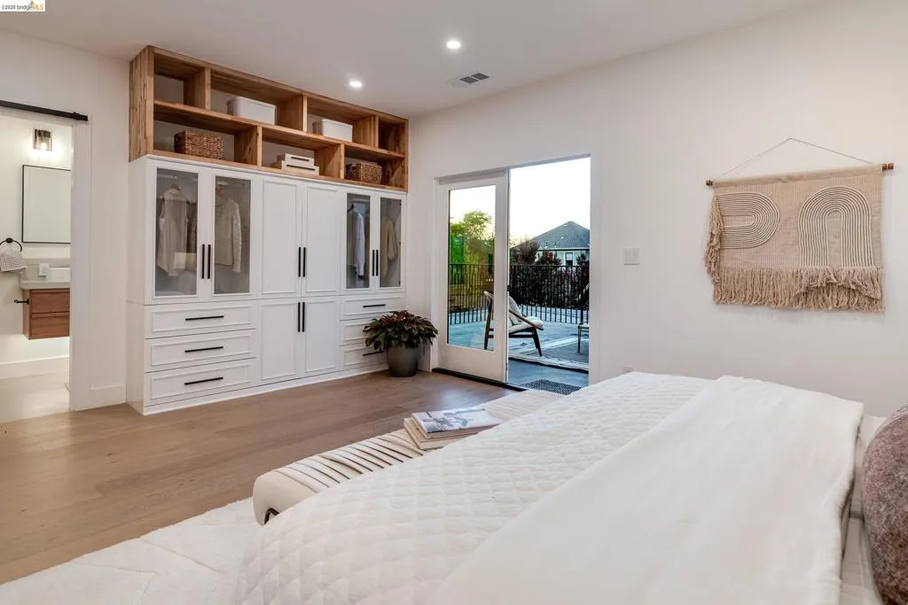 Built-in white cabinetry with glass-front uppers and wood-finish open shelving
