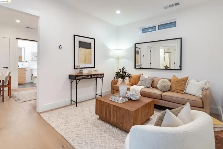 Light wood-finish flooring complements the neutral color palette throughout this living area