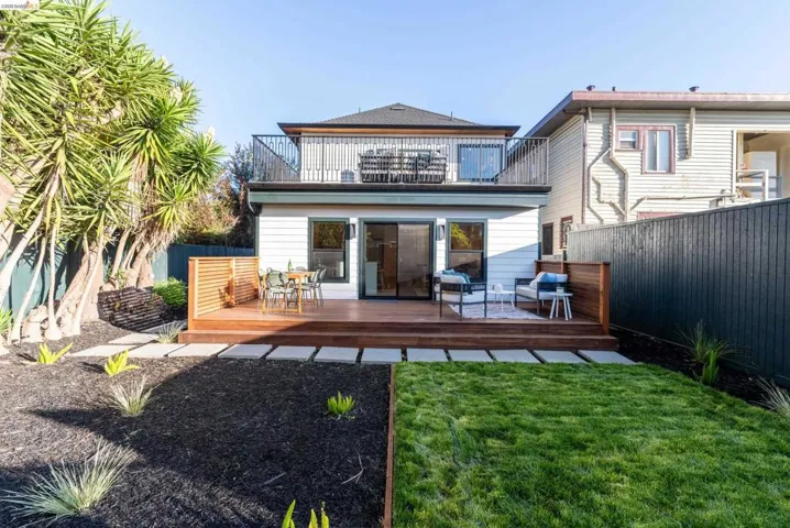 Expansive backyard featuring a multi-level wood-finish deck with privacy fencing