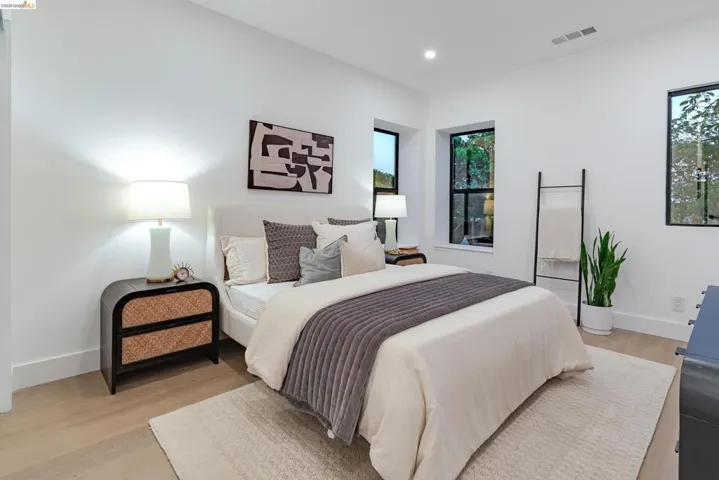 Light-filled room featuring white walls, recessed lighting, and wood-finish flooring