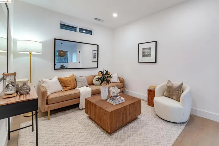 Bright living area featuring wood-finish flooring and a geometric-patterned area rug