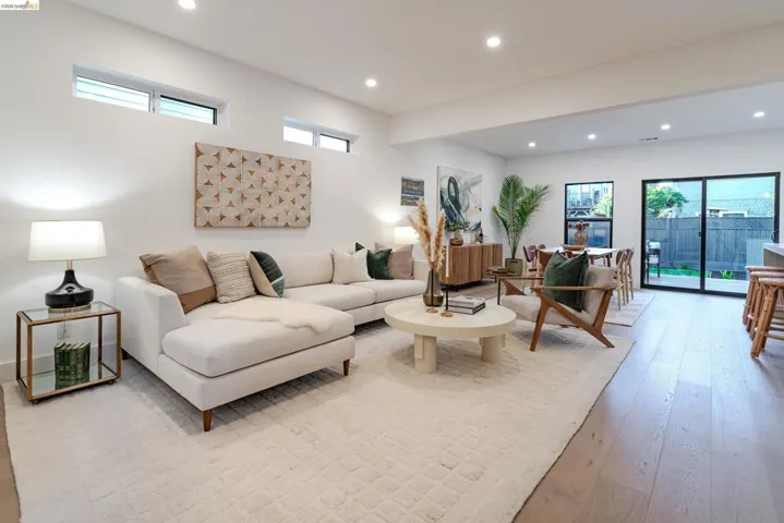 Open-concept living space featuring high ceilings with recessed lighting, transom windows, and light wood-finish flooring