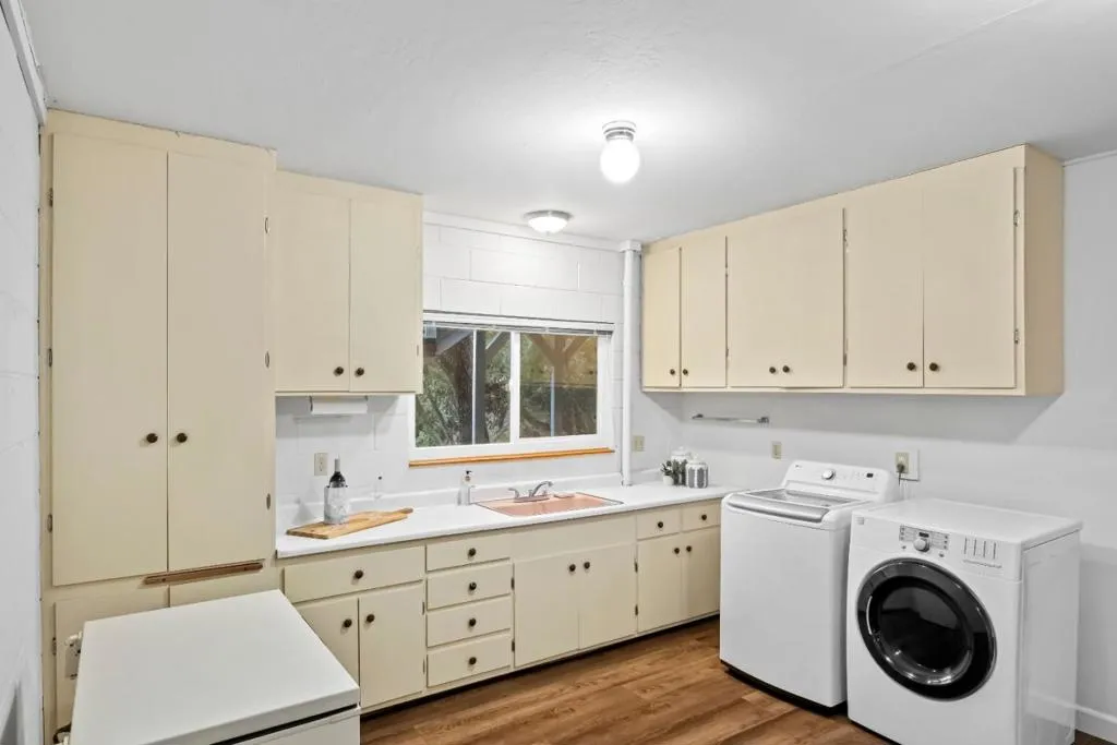 Utility / laundry room with a sink, loads of cabinets and counter space