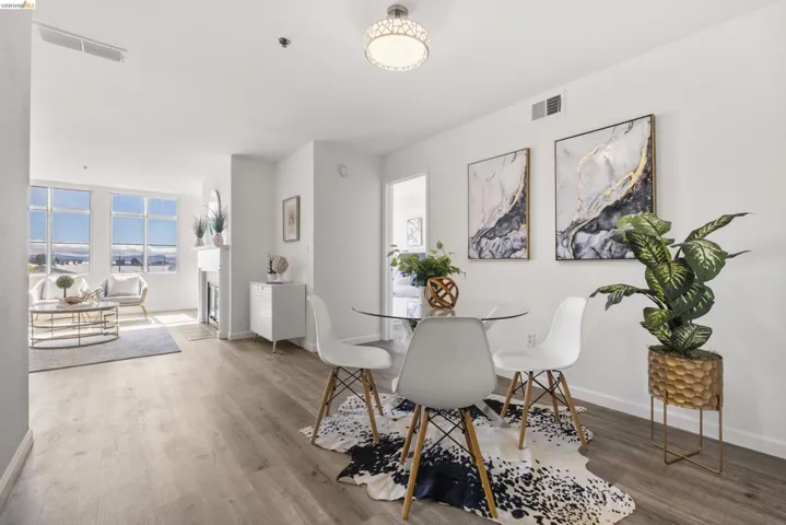 Open-concept living space featuring wood-finish flooring, a contemporary ceiling light fixture, and a decorative fireplace