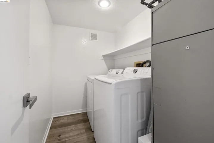 Dedicated utility area featuring wood-finish flooring, a built-in white shelf, and recessed ceiling lighting