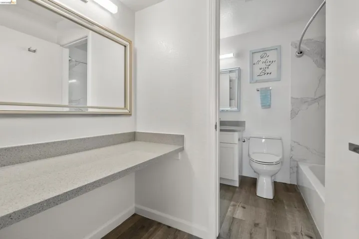 Vanity area featuring an expansive light-toned countertop and a wide framed mirror