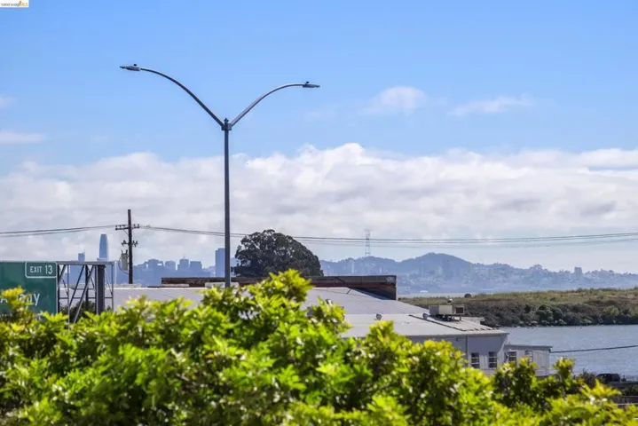 Distant city skyline featuring prominent structures and a body of water under a partly cloudy sky